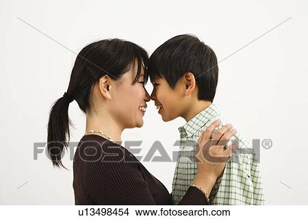Picture - Asian mother and young son touching noses and smiling.. Fotosearch