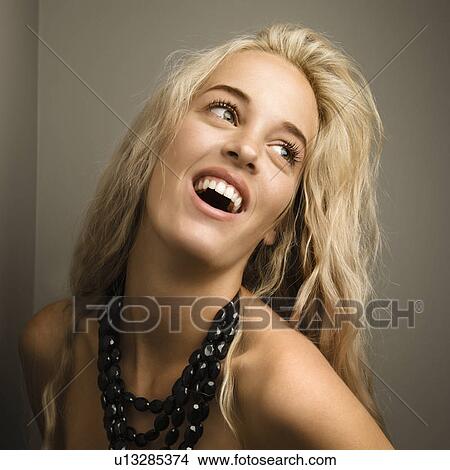 Picture - Attractive blonde woman looking to side wearing beaded necklace. . Fotosearch