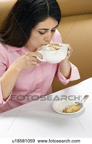 Stock Photo - Attractive Hispanic woman drinking cappuccino.. Fotosearch