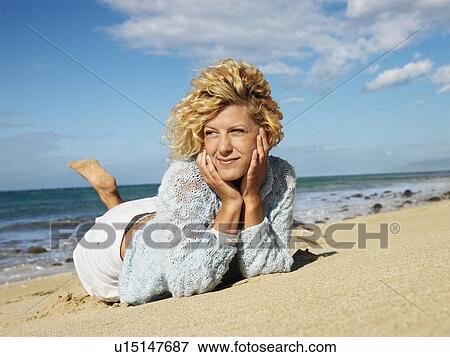 Attractive young blond woman lying in sand on Maui, Hawaii beach with head resting on hands. View Large Photo Image Stock Photo - Attractive young blond woman lying in sand on Maui, Hawaii beach with head resting on hands.. Fotosearch