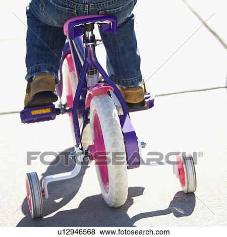 Back view of girl riding bicycle with training wheels View Large Photo Image Stock Photo - Back view of girl riding bicycle with training wheels. Fotosearch