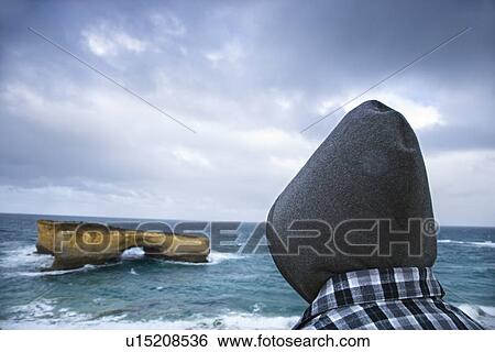 Back view of person wearing hooded clothing facing rock formation in arch shape as seen from Great Ocean Road in Australia. View Large Photo Image Stock Photograph - Back view of person wearing hooded clothing facing rock formation in arch shape as seen from Great Ocean Road in Australia.. Fotosearch