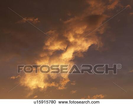 Stock Image - Beautiful clouds in orange-yellow sky.. Fotosearch