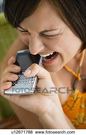 Biting phone and making facial expression View Large Photo Image Stock Photo - Biting phone and making facial expression. Fotosearch