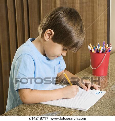 Stock Photo - Boy concentrating on homework. Fotosearch
