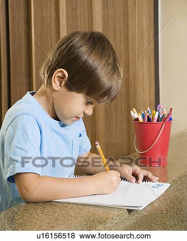 Stock Photo - Boy concentrating on homework. Fotosearch