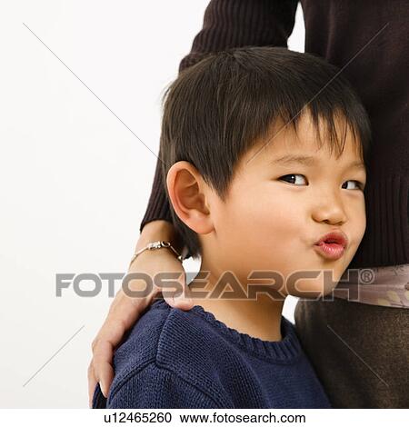 Boy making funny face standing next to mother View Large Photo Image Stock Image - Boy making funny face standing next to mother. Fotosearch