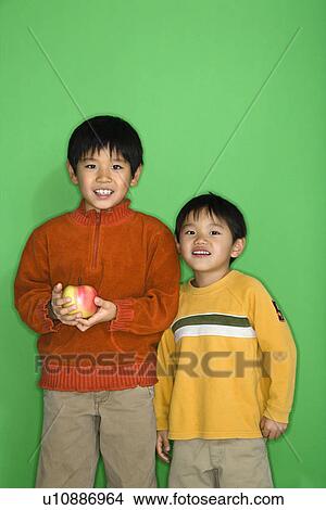 Picture - Boys holding apple smiling. Fotosearch