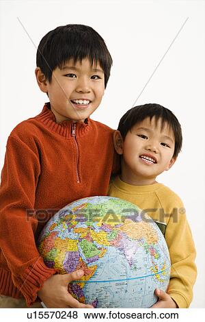Stock Photo - Boys holding world globe and smiling.. Fotosearch