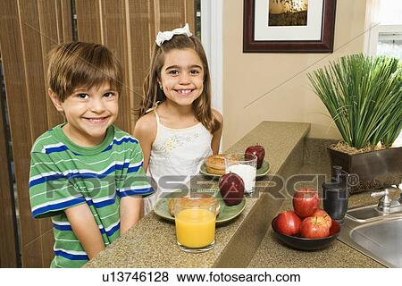 Brother and sister sitting at kitchen bar with healthy breakfast View Large Photo Image Stock Photo - Brother and sister sitting at kitchen bar with healthy breakfast. Fotosearch