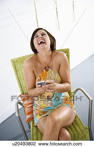Brunette woman holding PDA and laughing View Large Photo Image Stock Image - Brunette woman holding PDA and laughing. Fotosearch