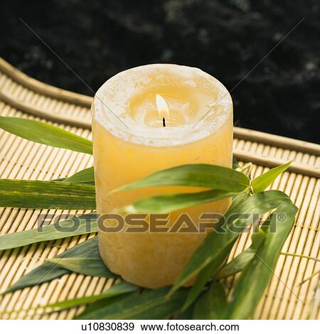 Burning candle on bamboo mat with bamboo leaves View Large Photo Image Stock Photo - Burning candle on bamboo mat with bamboo leaves. Fotosearch
