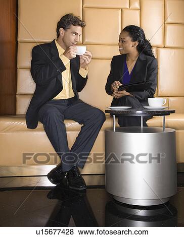 Stock Photo - Businessman and woman drinking coffee. Fotosearch