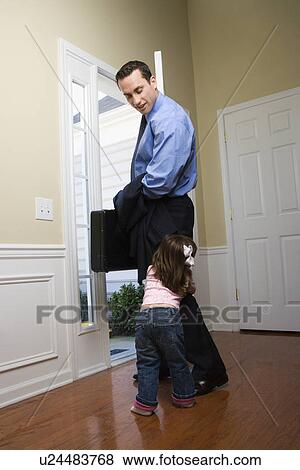 Businessman at open door with briefcase with daughter tugging on his leg View Large Photo Image Stock Photo - Businessman at open door with briefcase with daughter tugging on his leg. Fotosearch