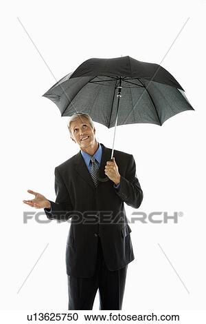 Stock Image - Businessman holding umbrella and gesturing. Fotosearch