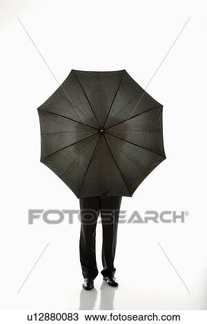 Businessman holding umbrella in front of body. View Large Photo Image Stock Image - Businessman holding umbrella in front of body.. Fotosearch