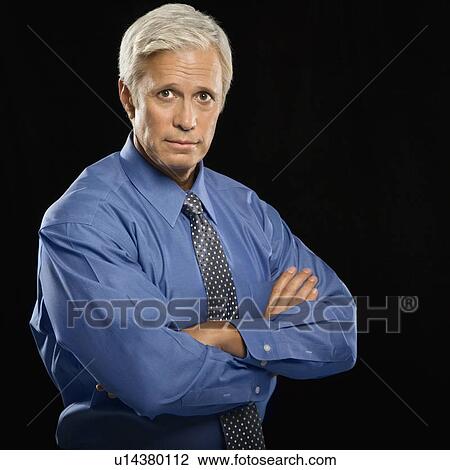 Businessman looking at viewer with arms crossed View Large Photo Image Stock Image - Businessman looking at viewer with arms crossed. Fotosearch