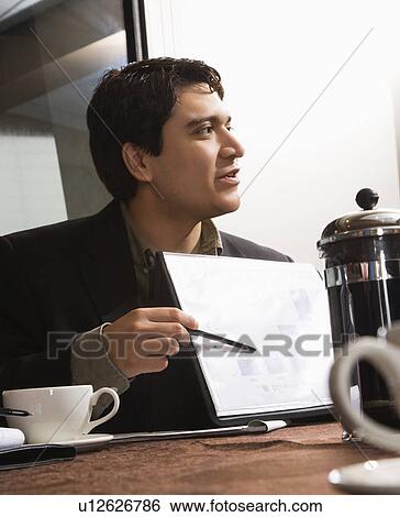 Businessman sitting at table pointing to bar graph. View Large Photo Image Stock Photograph - Businessman sitting at table pointing to bar graph.. Fotosearch