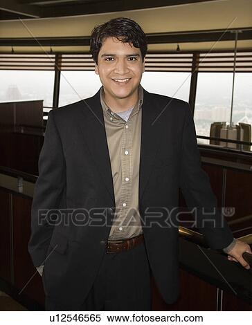 Stock Photography - Businessman standing and smiling at viewer.. Fotosearch
