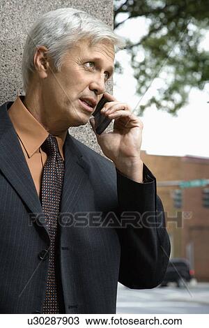 Stock Image - Businessman talking on cell phone. Fotosearch