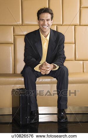 Stock Photograph - Businessman with briefcase smiling at viewer. Fotosearch