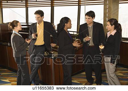 Businesspeople in bar drinking and conversing View Large Photo Image Stock Image - Businesspeople in bar drinking and conversing. Fotosearch