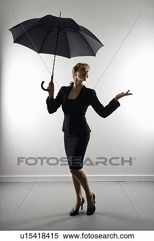 Businesswoman holding umbrella and gesturing. View Large Photo Image Stock Photography - Businesswoman holding umbrella and gesturing.. Fotosearch