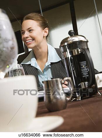 Businesswoman smiling at table with coffee and beverages View Large Photo Image Stock Photograph - Businesswoman smiling at table with coffee and beverages. Fotosearch