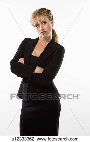 Stock Image - Businesswoman standing with arms crossed and giving stern expression . Fotosearch