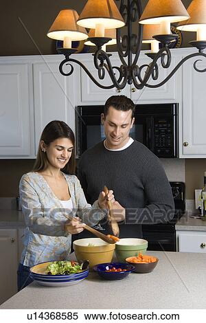 Caucasian couple making salad at kitchen counter. View Large Photo Image Stock Photography - Caucasian couple making salad at kitchen counter.. Fotosearch