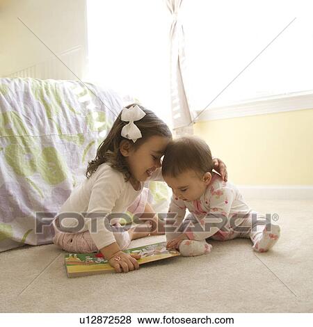 Caucasian girl children sitting on bedroom floor looking at book. View Large Photo Image Stock Photo - Caucasian girl children sitting on bedroom floor looking at book.. Fotosearch