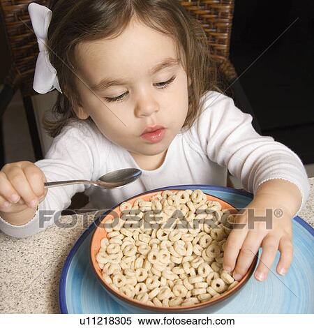 Stock Photography - Caucasian girl eating bowl of cereal.. Fotosearch