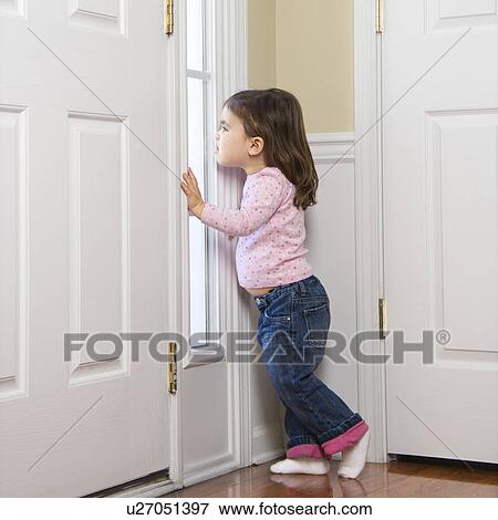 Caucasian girl toddler peeking out of window by door. View Large Photo Image Stock Photo - Caucasian girl toddler peeking out of window by door.. Fotosearch