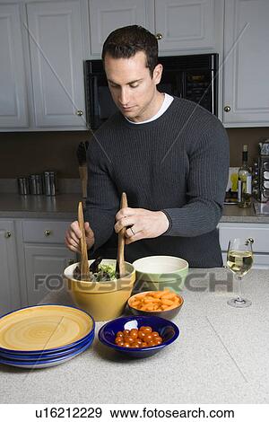 Caucasian man making salad on kitchen counter. View Large Photo Image Stock Photo - Caucasian man making salad on kitchen counter.. Fotosearch