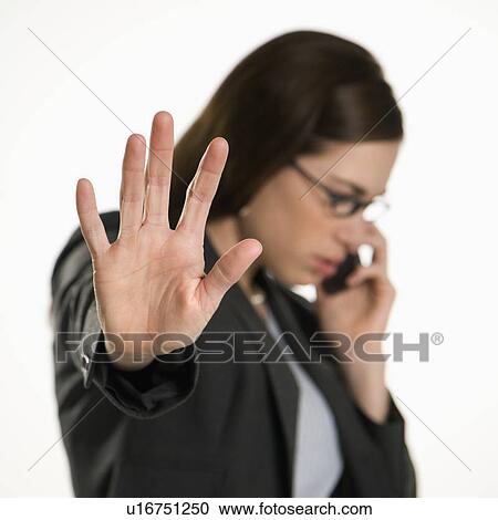 Caucasian mid adult professional business woman talking on cell phone holding hand out to stop viewer. View Large Photo Image Stock Image - Caucasian mid adult professional business woman talking on cell phone holding hand out to stop viewer. . Fotosearch