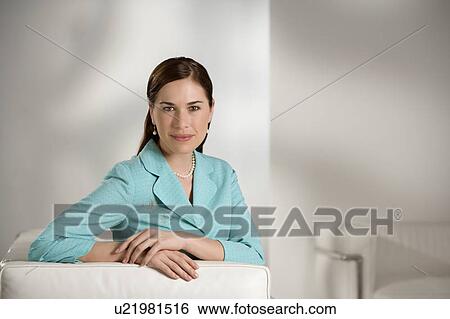 Caucasian mid adult professional business woman sitting in modern office looking at viewer and smiling. View Large Photo Image Stock Photograph - Caucasian mid adult professional business woman sitting in modern office looking at viewer and smiling.. Fotosearch