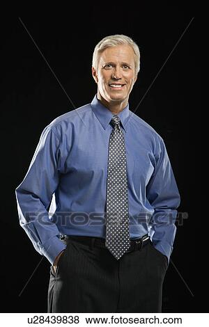 Caucasian middle aged businessman looking at viewer with hands in pockets. View Large Photo Image Stock Photo - Caucasian middle aged businessman looking at viewer with hands in pockets.. Fotosearch