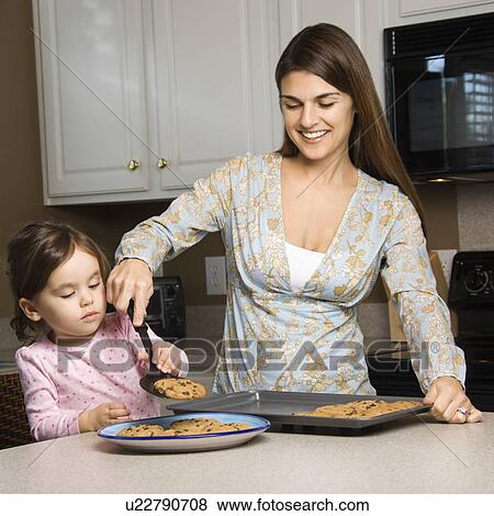 Stock Photo - Caucasian mother and daughter with cookies.. Fotosearch
