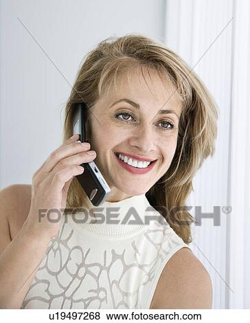 Stock Photo - Caucasian woman smiling on cellphone.. Fotosearch