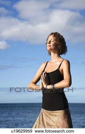 Caucasian young adult female meditating by the Pacific ocean of Maui, Hawaii. View Large Photo Image Stock Photo - Caucasian young adult female meditating by the Pacific ocean of Maui, Hawaii.. Fotosearch