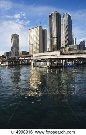 Stock Photograph - Circular Quay Railway Station in Sydney Cove with view of downtown skyscrapers in Sydney, Australia.. Fotosearch