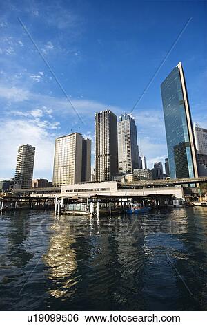 Stock Photograph - Circular Quay Railway Station in Sydney Cove with view of downtown skyscrapers in Sydney, Australia. Fotosearch