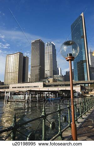 Stock Photography - Circular Quay Railway Station in Sydney Cove with view of downtown skyscrapers and lammpost in Sydney, Australia.. Fotosearch