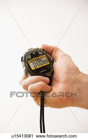 Stock Image - Close-up of adult male hand holding stopwatch. Fotosearch
