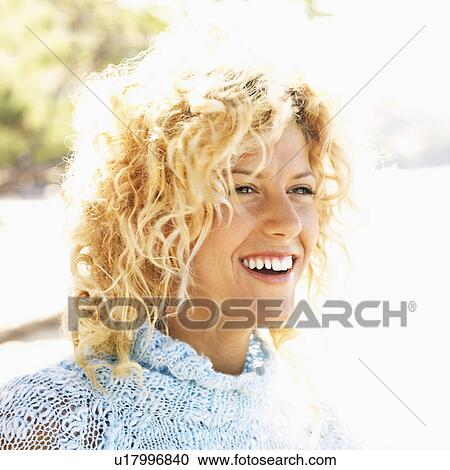 Stock Image - Close up portrait of attractive young blond woman smiling.. Fotosearch