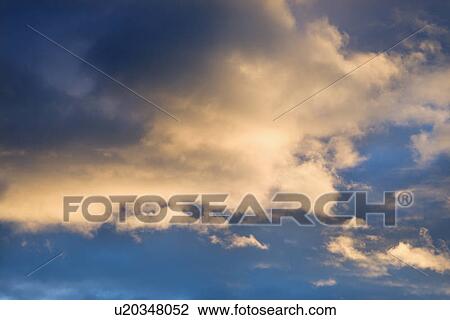 Stock Image - Colorful cumulus clouds in sky.. Fotosearch