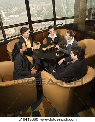 Ethnically diverse businesspeople sitting at table in restaurant talking. View Large Photo Image Stock Image - Ethnically diverse businesspeople sitting at table in restaurant talking.. Fotosearch