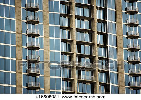 Stock Image - Exterior of high rise building with mirrored windows and balconies. Fotosearch