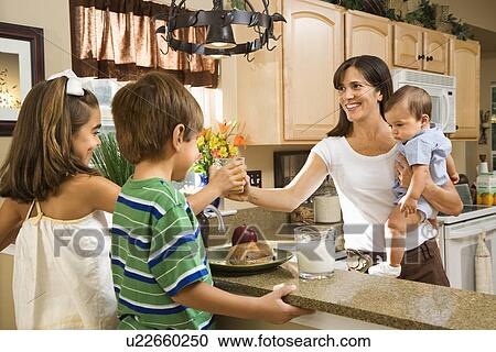 Stock Image - Family in kitchen with breakfast . Fotosearch