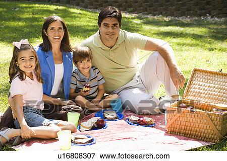 Family picnicking in the park View Large Photo Image Stock Photo - Family picnicking in the park. Fotosearch